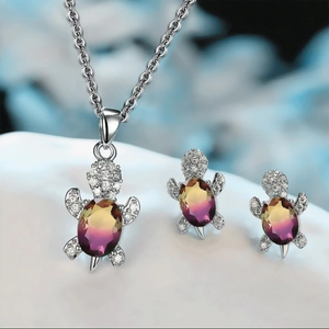 Close-up of turtle necklace and earrings set with gradient gemstones and crystals