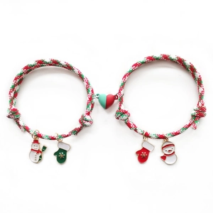 Detalle de pulseras de Navidad para parejas con corazón magnético y colgantes festivos