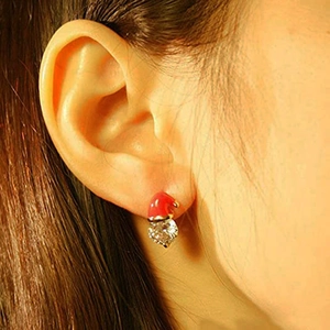 Close-up of festive red enamel snowman hat earrings with a heart-shaped zircon crystal