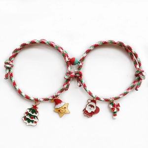 Detalle de pulseras magnéticas navideñas para parejas con dijes de Papá Noel y trenzados