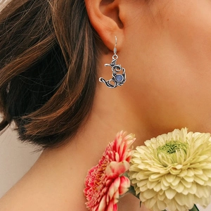 Détail de boucles d'oreilles lune rétro en argent creux avec pierre de lune bleue