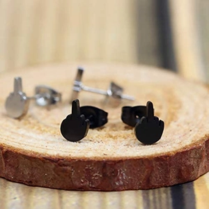 Close-up of punk middle finger earrings in black and silver finishes on a wood stand