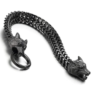 Detalle macro de las cabezas de lobo vikingo en acero negro y eslabones de cadena