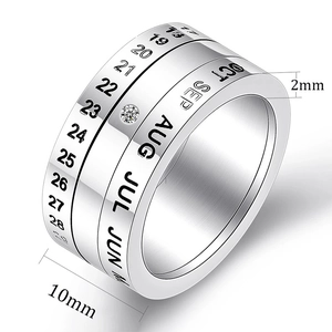 Rotating stainless steel calendar ring with engraved dates, months, and a cubic zirconia stone