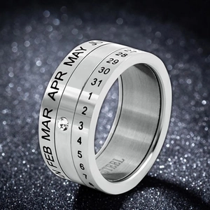 Macro shot of rotatable stainless steel calendar ring with engraved dates and small crystal