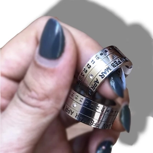 Detail view of rotating calendar ring with engraved months and small zircon stone
