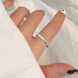 Détail d'une bague mate en acier inoxydable argenté portée sur un doigt