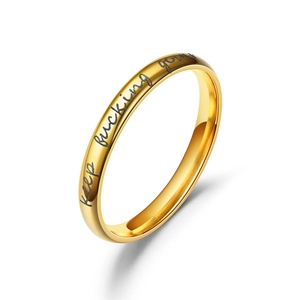 Detail van gepolijste gouden ring met zwart gegraveerde Keep fucking going tekst