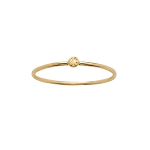 Detail showing a minimalist gold titanium ring with a round yellow bezel-set stone