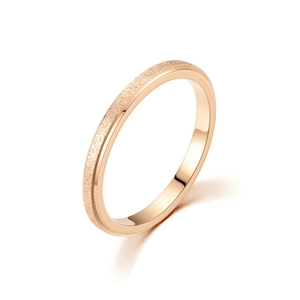 Détail d'une bague en acier inoxydable or rose avec finition sablée et polie à moitié