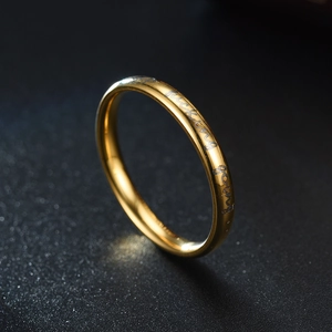 Macro-opname van gouden roestvrijstalen ring met keep fucking going motiverende gravure
