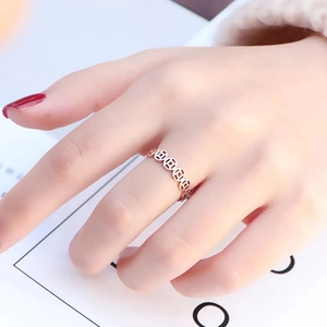 Macro detail of rose gold hollow coin pattern ring showing fine polished metal texture