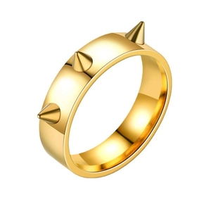 Dettaglio di un anello largo dorato stile punk con tre punte metalliche coniche affilate