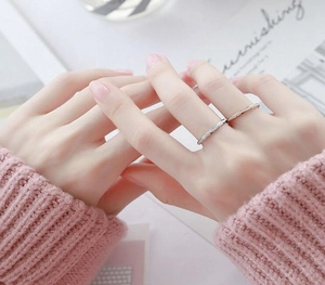 Détail de bagues superposées en acier inoxydable argenté et doré rose avec texture