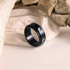 Macro detail of 8mm black stainless steel rotating stress relief ring with Tai Chi pattern