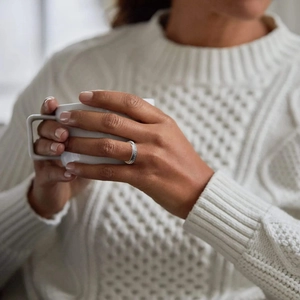 Detalle de anillo giratorio de plata con diamantes en la mano de una modelo