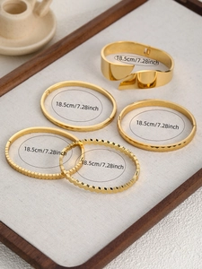 Dettaglio del set di cinque bracciali in acciaio inossidabile placcato oro 18k testurizzati