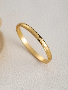 Dettaglio del bracciale geometrico sfaccettato in acciaio inossidabile placcato oro 18k con fibbia