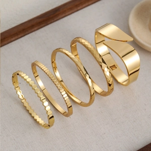 Set di cinque bracciali rigidi in acciaio inossidabile placcato oro con trame geometriche