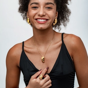Ensemble bijoux dorés polis aux formes organiques sur mannequin avec collier et bague