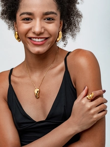 Parure de bijoux dorés en forme de cacahuète avec collier et boucles sur un mannequin
