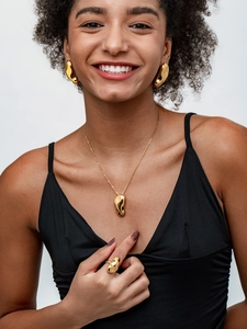 Vue rapprochée d'un modèle portant un ensemble de bijoux dorés aux formes fluides