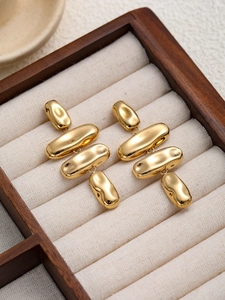 Gros plan détaillé de boucles d'oreilles dorées dans une boîte à bijoux en bois de luxe