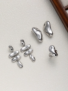 Gros plan d'un ensemble de bijoux en acier inoxydable style métal liquide sur fond blanc