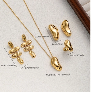 Parure de bijoux dorés minimalistes avec collier, boucles d'oreilles et bague sur fond chaud