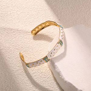 Detail von vergoldeter C-Manschette mit weißem Email, blauen Strasssteinen und Sternen