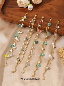 Detail of adjustable golden layered bracelet with colorful acrylic flowers and pearls