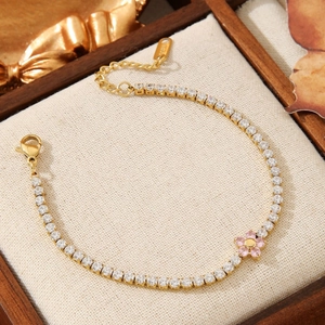 Elegant gold-tone tennis bracelet featuring pink zircon flowers and white pavé crystals