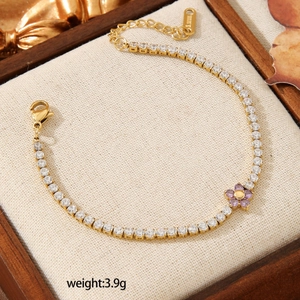 Elegant gold tennis bracelet with purple flower pendant and round crystals, weighing 3.9g