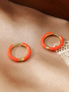 Detailopname van oranje emaille oorringen met 18k goud vergulde roestvrijstalen rand