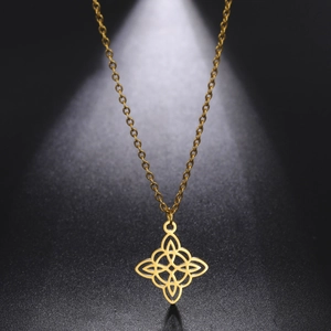 Détail macro d'un pendentif nœud celtique doré sur chaîne fine sous un éclairage studio