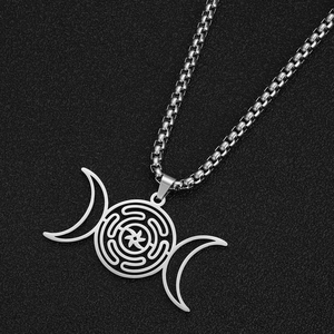 Macro-opname van zilveren Hecate-wielketting met maan hanger op een zwarte gestructureerde achtergrond
