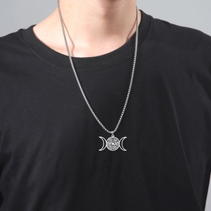 Detail van zilveren roestvrijstalen Hecate-wielketting gedragen op een zwart t-shirt