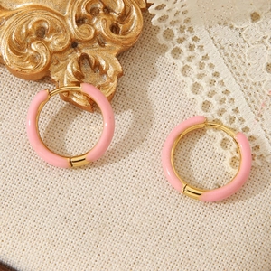 Roze emaille ronde oorringen van 18k verguld roestvrij staal op een vintage kanten achtergrond