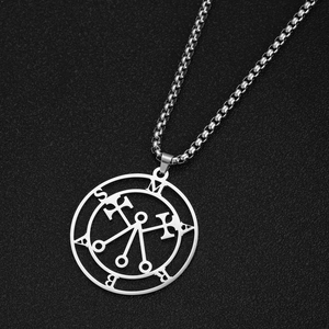 Macro view of the stainless steel Marbas symbol pendant with box chain on black texture