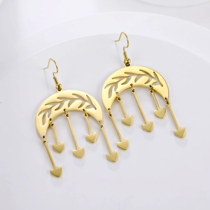 Macro shot of gold celestial earrings featuring crescent moons and heart fringe tassels