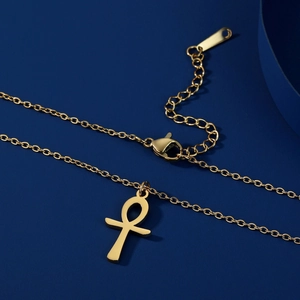 Dettaglio della collana con ciondolo Ankh dorato, finitura lucida e chiusura a moschettone