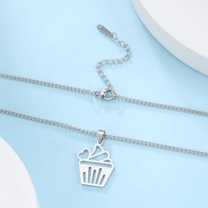 Detailed view of cupcake pendant with heart detail on a fine silver link chain necklace