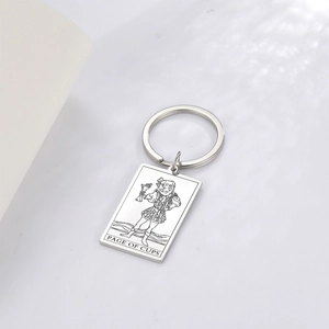 Macro shot of silver stainless steel keychain featuring Page of Cups tarot card engraving