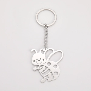 Detailed macro view of a cute hollow bee charm on a polished stainless steel keychain