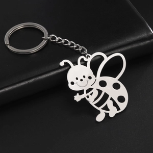 Detailed macro shot of a hollow-out bee pendant keychain in polished stainless steel finish