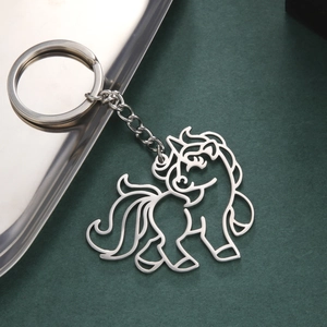 Detailed close-up of a hollow unicorn pendant keychain on a silver metal tray