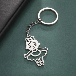 Polished stainless steel ballerina pendant keychain with cutout design on green texture
