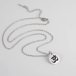 Détail macro du collier pendentif Om yoga en acier inoxydable argenté avec chaîne réglable