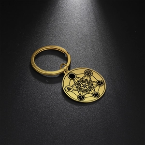 Macro detail of gold stainless steel keychain featuring a sacred geometry hexagram design