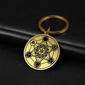 Close-up of gold stainless steel keychain featuring etched Metatron's Cube sacred geometry